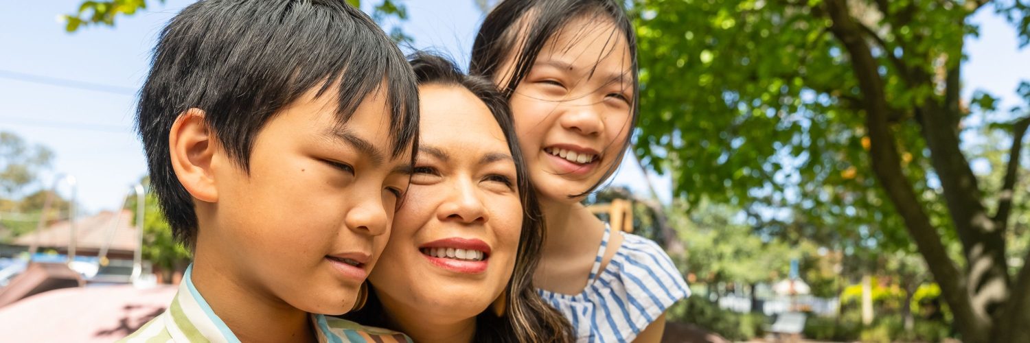 Close up of a woman and her two children in a garden setting