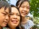 Close up of a woman and her two children in a garden setting