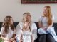A woman and her three children smiling and laughing on a sofa