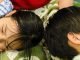 Two children lying in their mother's lap